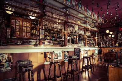 内部的一个酒吧凳子,玻璃杯子和空瓶子连接到屋顶在马德里
